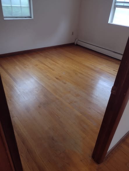 Empty room with clean hardwood floor after carpet removal